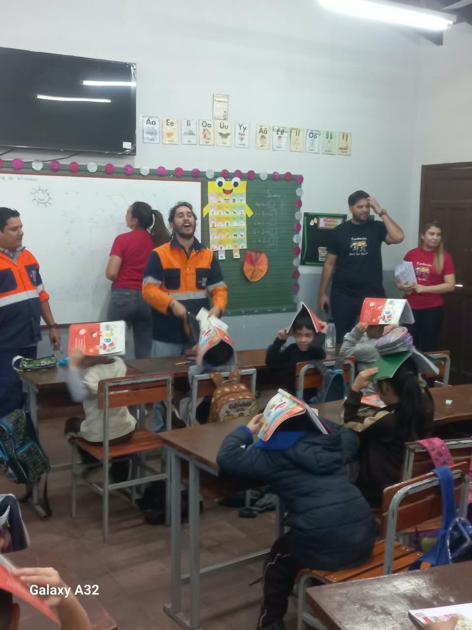 Niños jugando con sombreros de papel durante la dinámica del taller