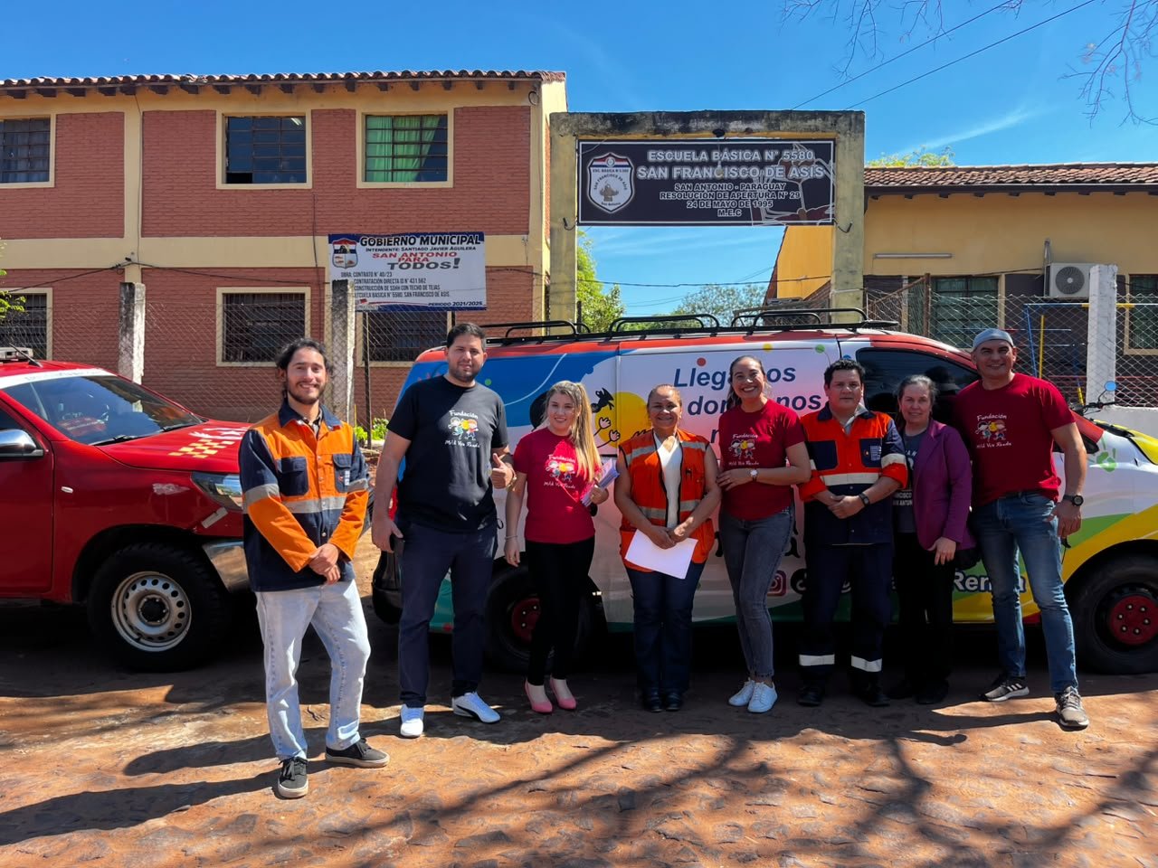 Equipo de la fundación y la SEN frente a la Unidad Móvil y la escuela en San Antonio